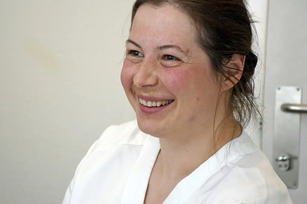 En kvinne som smiler til kameraet