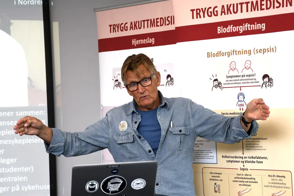 En mann som peker på en bærbar datamaskin