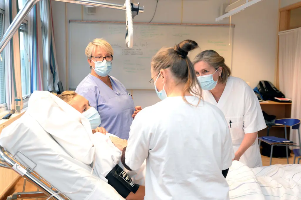 En gruppe mennesker i kirurgiske skrubber og masker