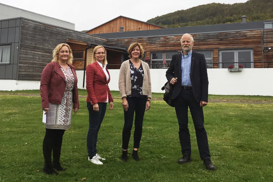 En gruppe mennesker som står foran en bygning