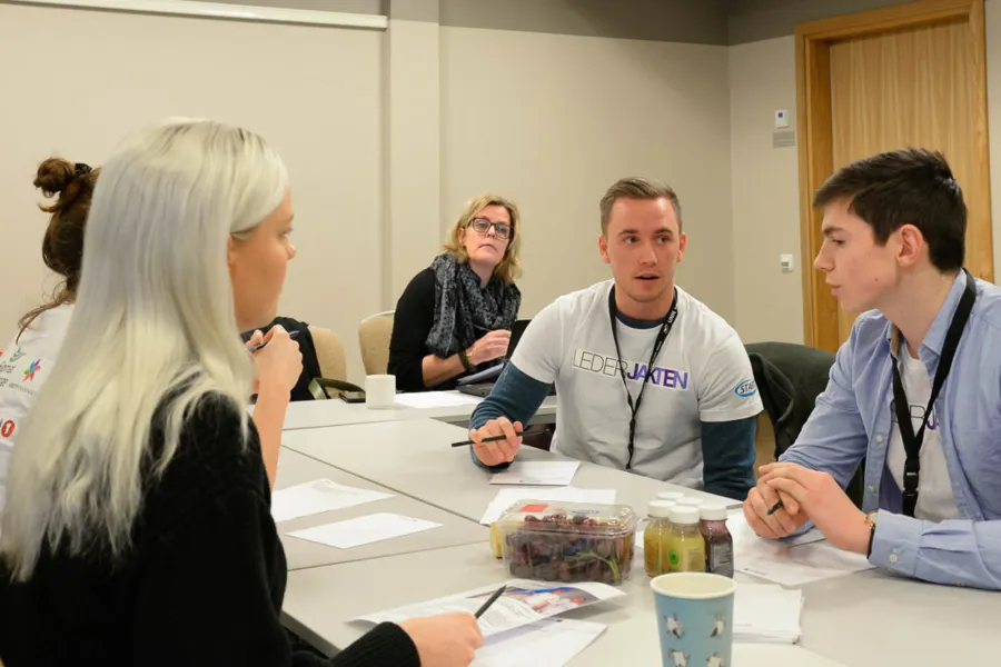 En gruppe mennesker som sitter rundt et bord