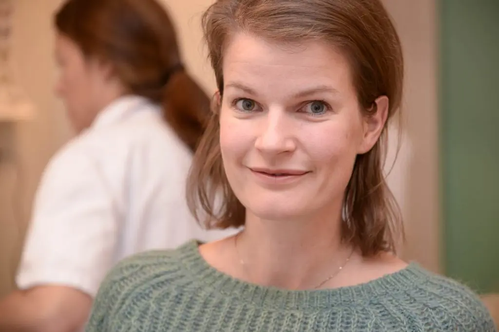 En kvinne som smiler til kameraet