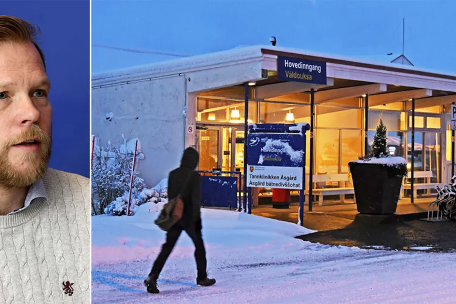 En mann som står foran en bygning med et skilt på