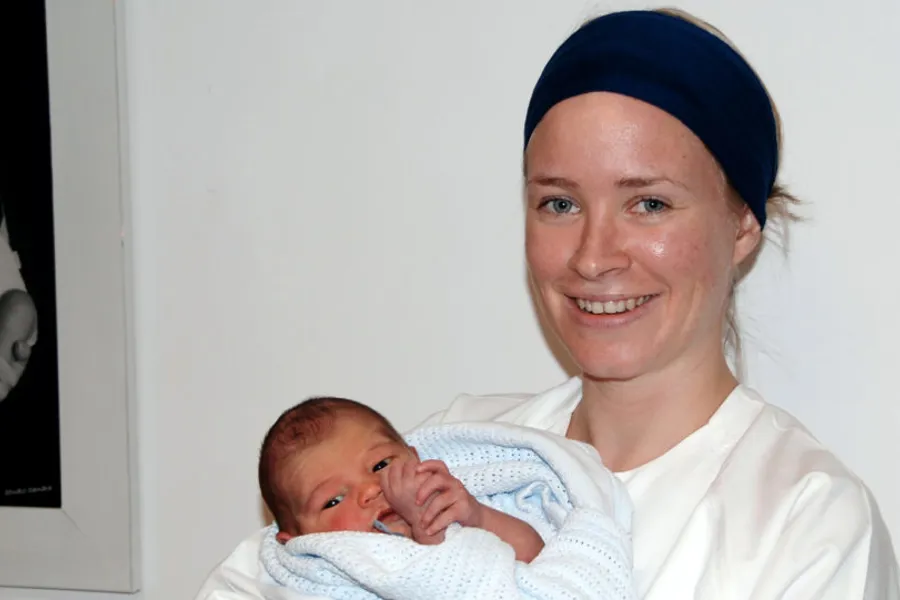 En kvinne som holder en baby
