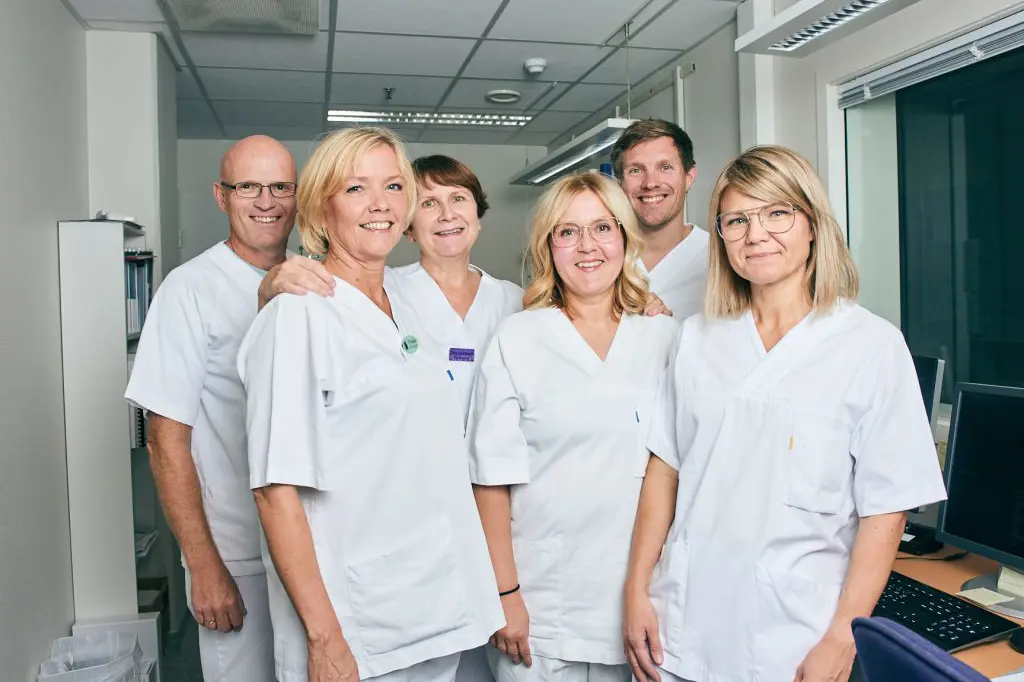 En gruppe mennesker iført hvite laboratoriefrakker