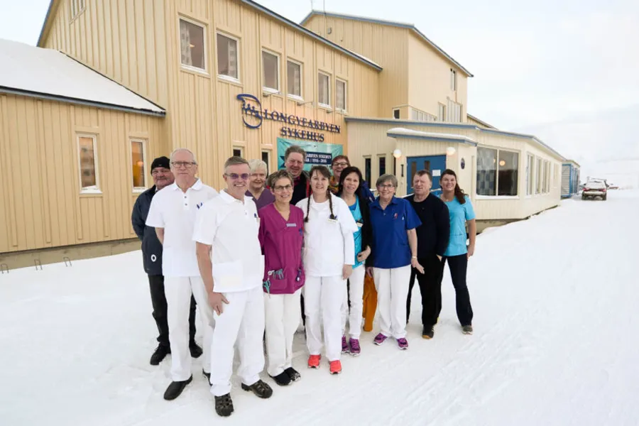 En gruppe mennesker som poserer for et bilde i snøen
