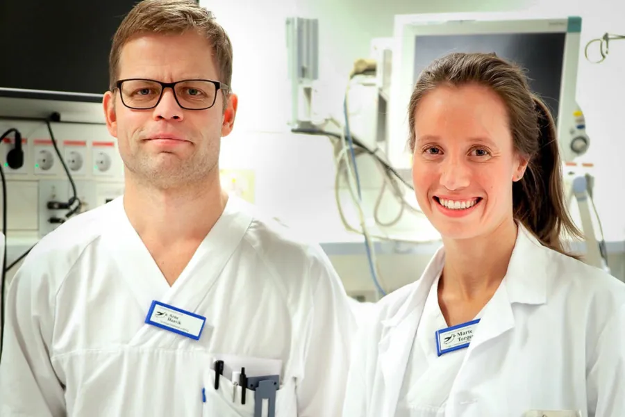 En mann og en kvinne i hvite laboratoriefrakker