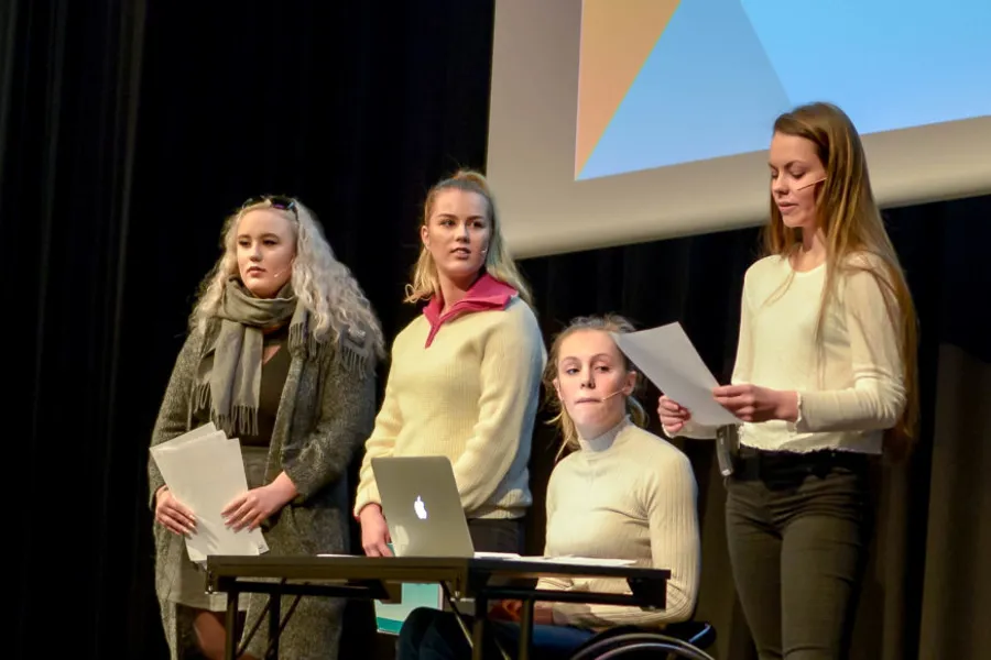 En gruppe kvinner som står foran en bærbar datamaskin