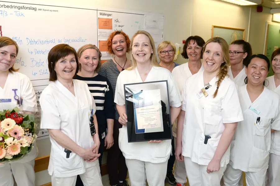 En gruppe kvinner i hvite laboratoriefrakker med sertifikat