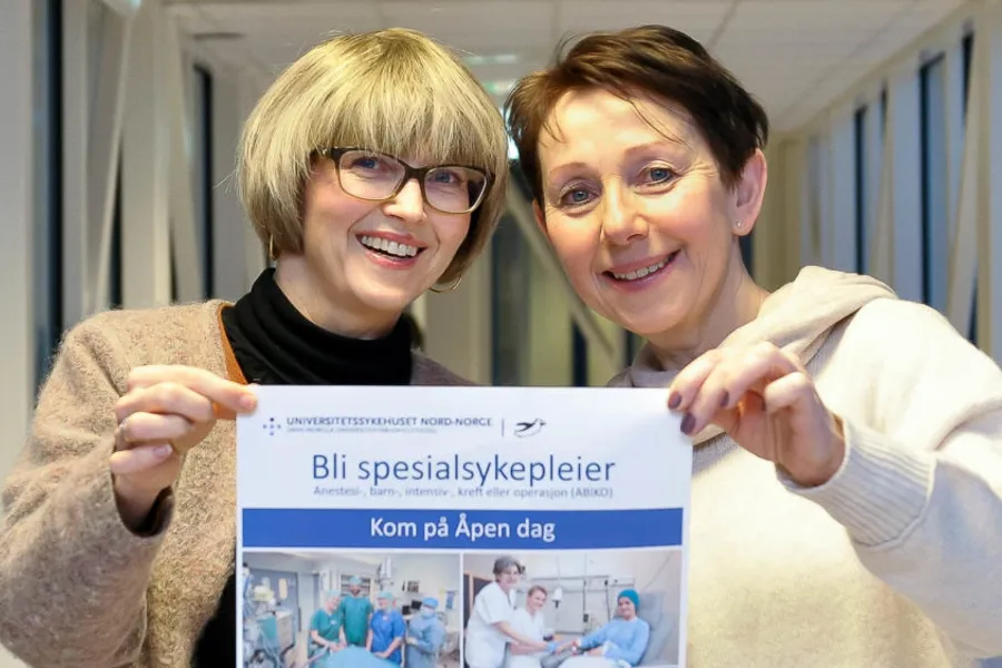 Et par personer som holder et skilt