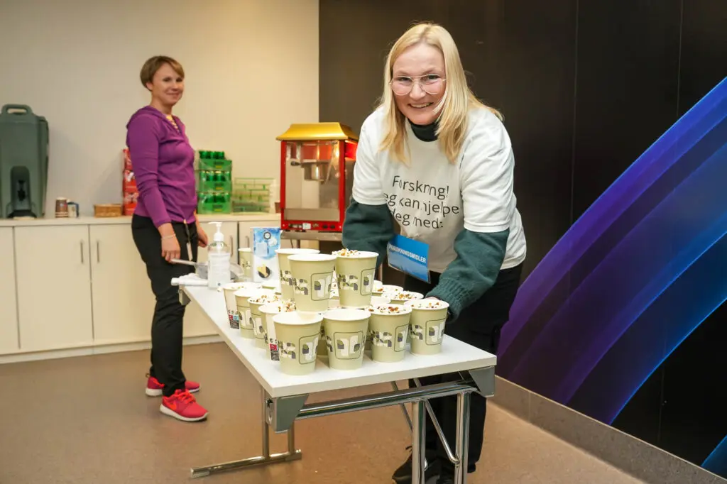 To damer, en popcornmaskin og masse popcorn