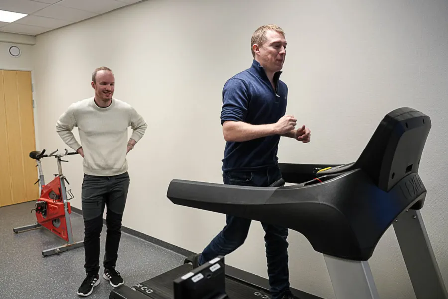 En løper på tredemølla, en annen følger med