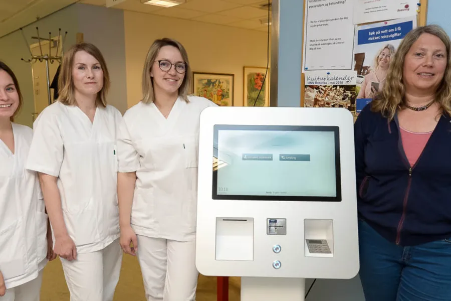 En gruppe kvinner som står ved siden av en datamaskin