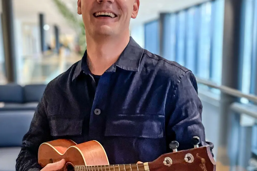 En mann som holder en gitar