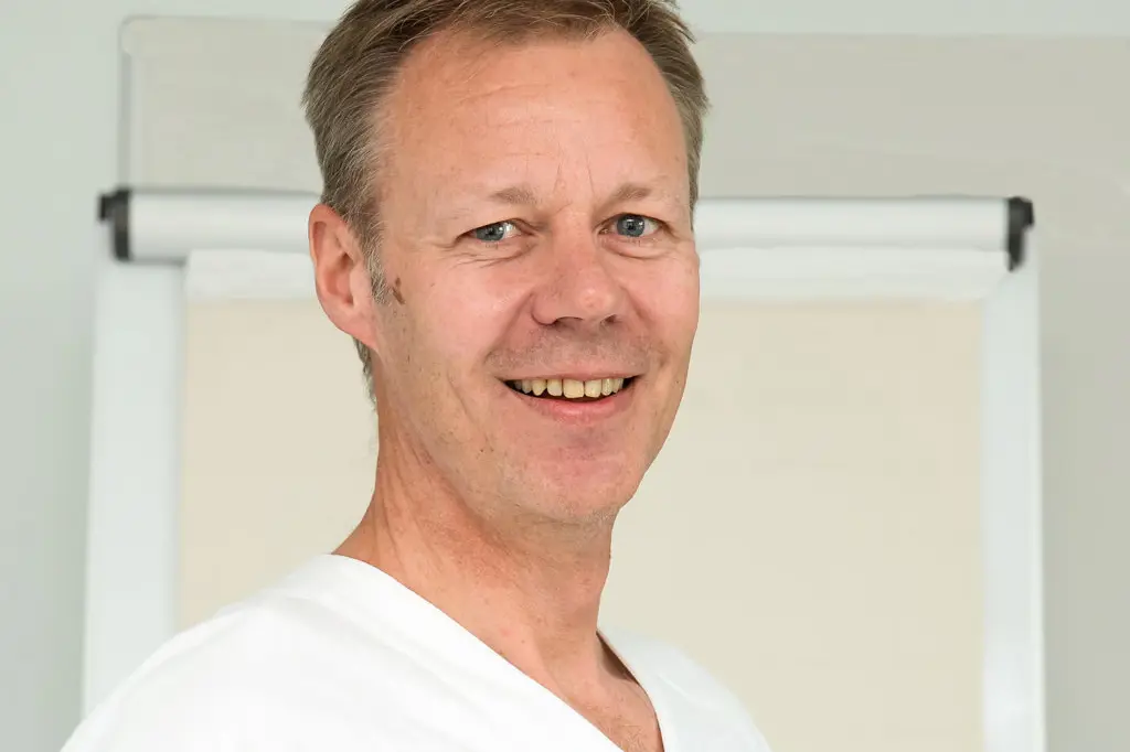 En mann som smiler til kameraet