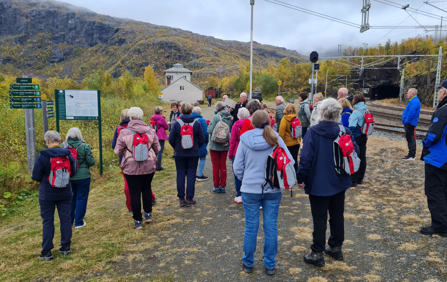 En gruppe mennesker som står på en ås