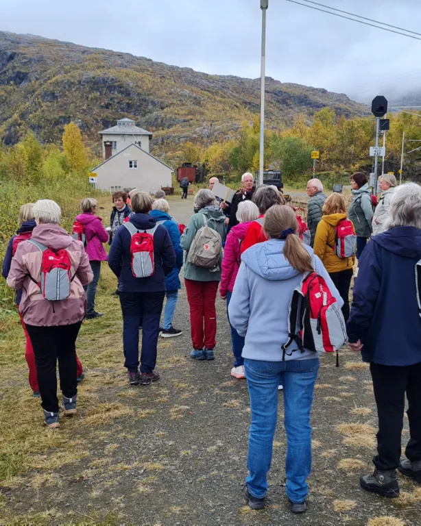 En gruppe mennesker som står på en ås
