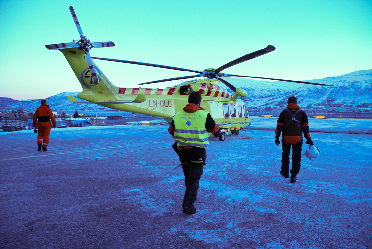 Helsepersonell som går mot et ambulansehelikopter