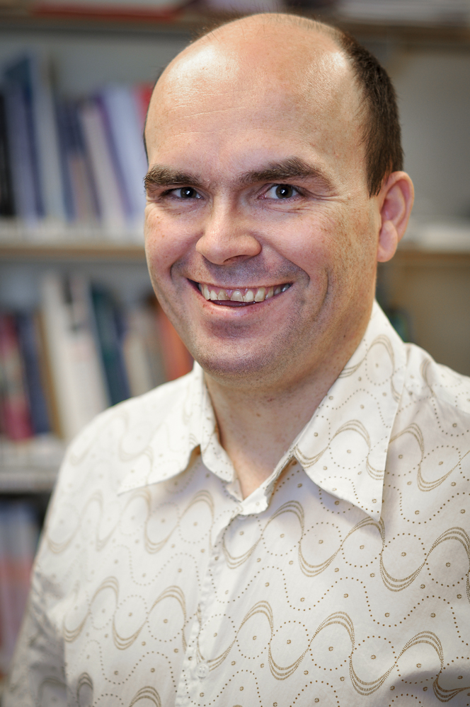 En mann som smiler til kameraet