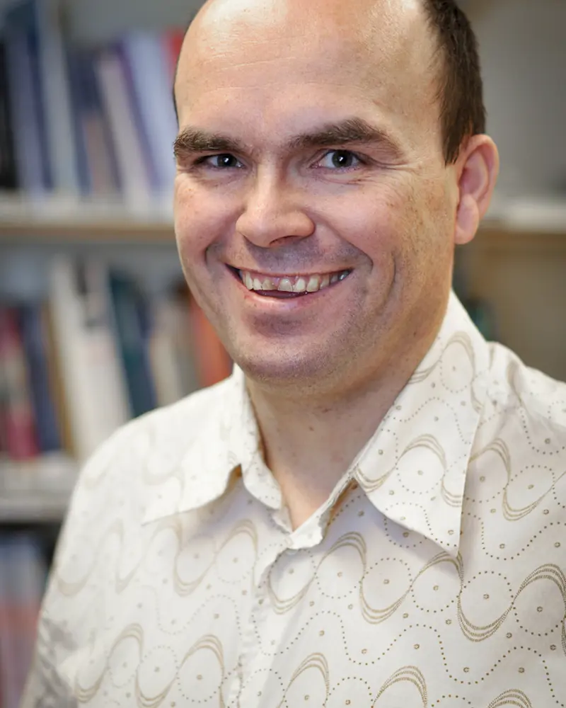 En mann som smiler til kameraet