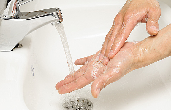 En hånd som holder en skje i en vask