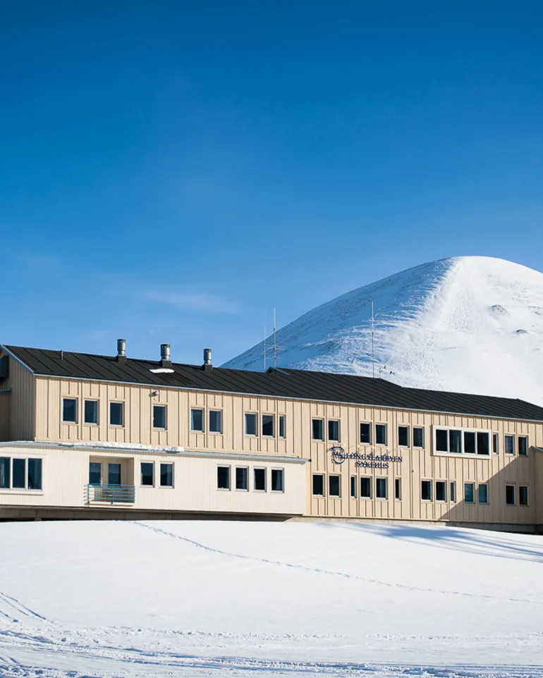 En bygning med et snødekt fjell i bakgrunnen