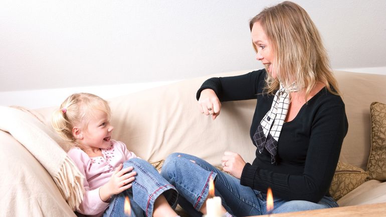 En kvinne og et barn som sitter på en sofa