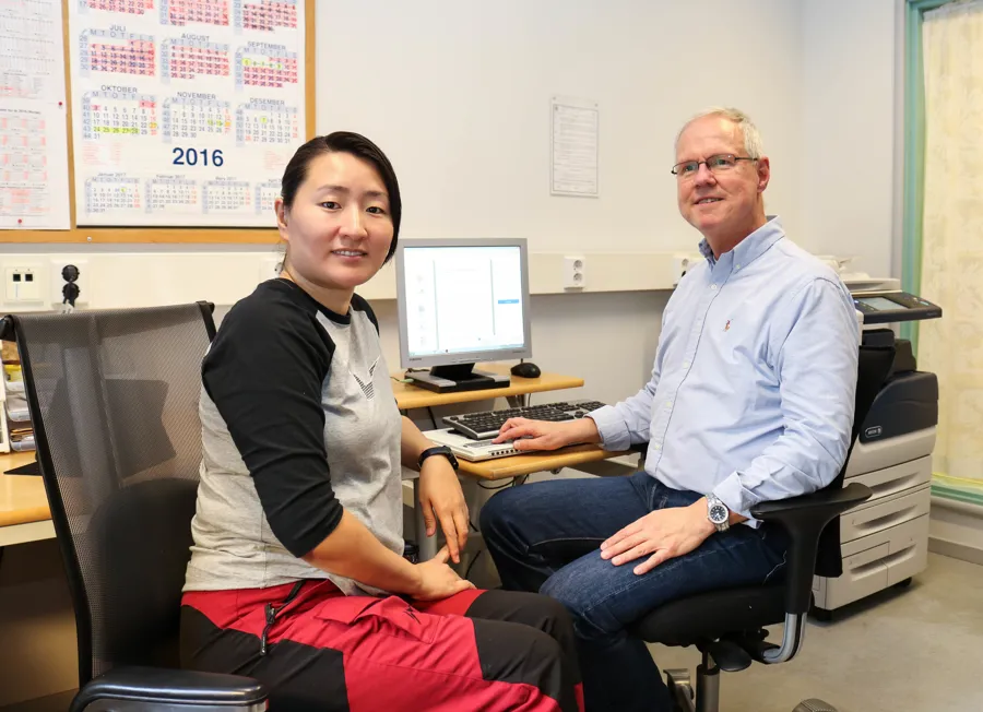 En mann og en kvinne som sitter ved et skrivebord med en datamaskin