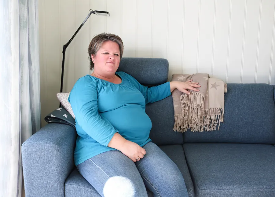 En kvinne som sitter på en sofa
