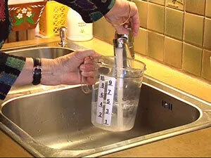 En person som heller en væske i et glass