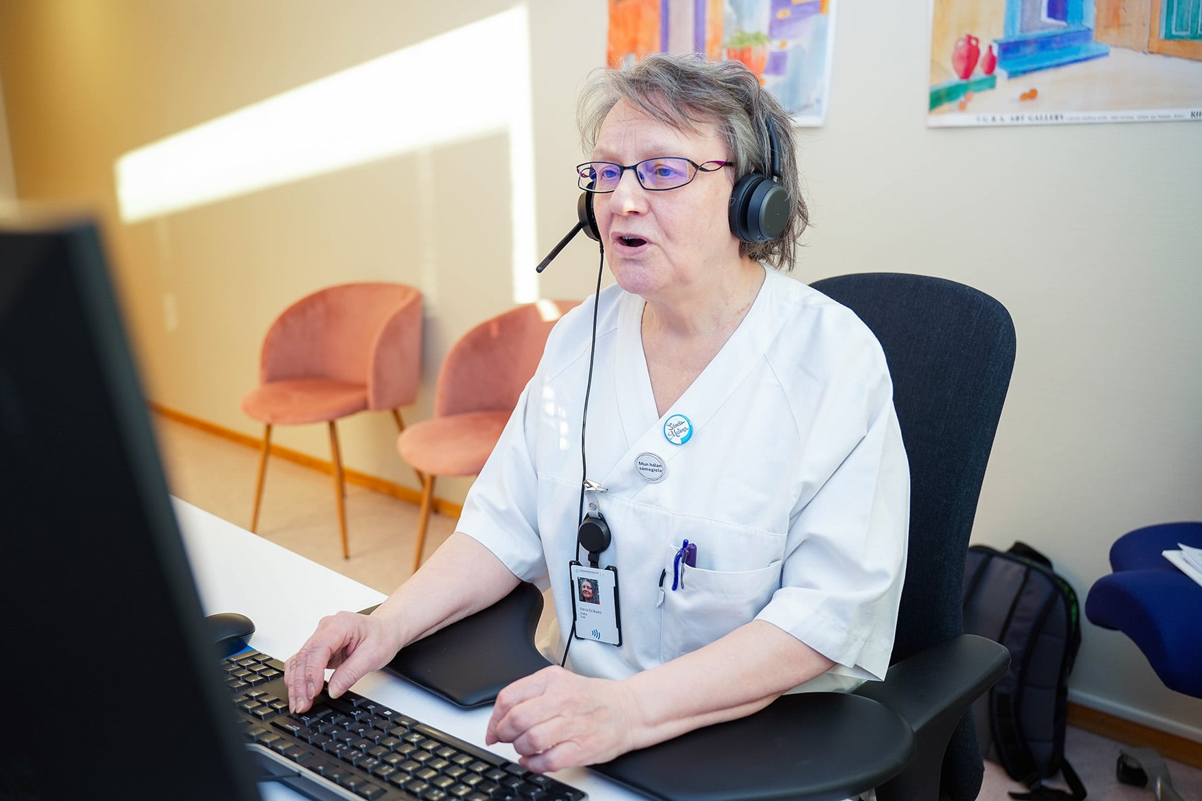 En person med hodetelefoner som sitter ved et skrivebord
