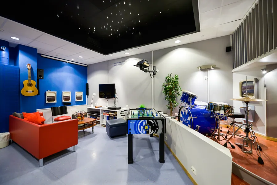 Et rom med en sofa og et bord med en gitar og andre musikkinstrumenter