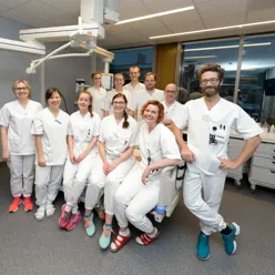 Gruppebilde av ansatte i et intensiv rom som poserer til kameraet