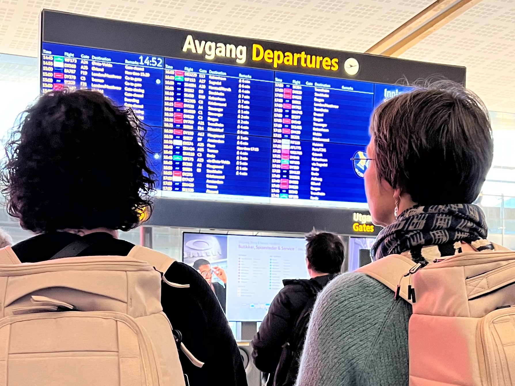 Personer som ser på en informasjonsskjerm