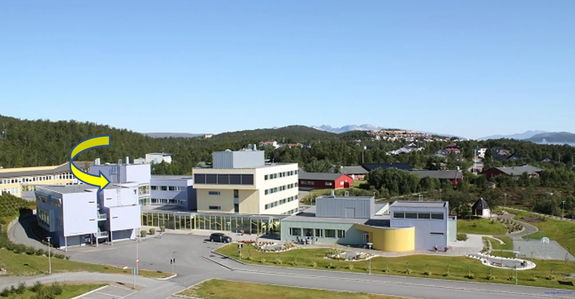 En gruppe bygninger med trær i bakgrunnen