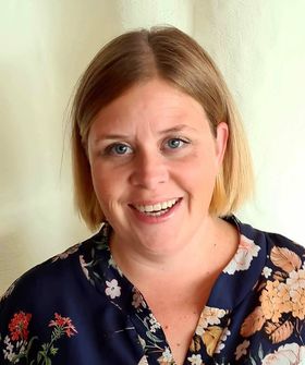 En kvinne som smiler til kameraet