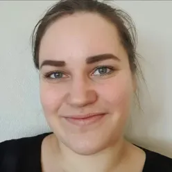 En kvinne som smiler til kameraet