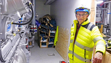 En person (iført sikkerhetsvest) i et varmerom